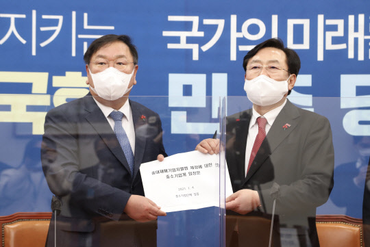 김기문 중소기업중앙회장(오른쪽)이 4일 국회에서 김태년 더불어민주당 원내대표에게 '중대재해기업처벌법' 제정에 반대하는 중소기업계 입장문을 전달하고 있다. <중소기업중앙회 제공>